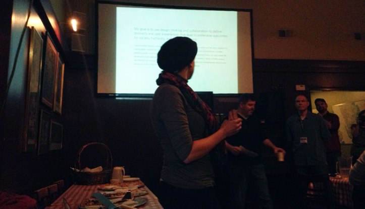 Kate Hotler looking stylish in a beret, presenting next to the pizza table